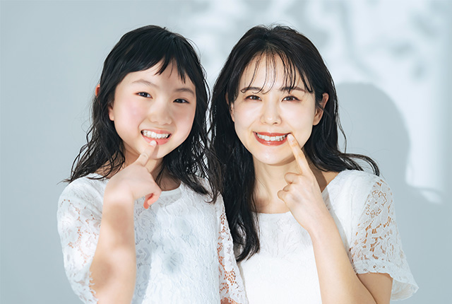 歯を見せている親子